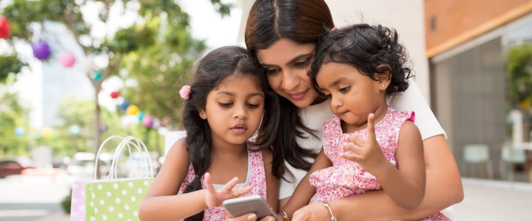 mother holding two children outside